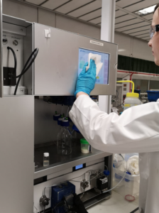 Purification Scientist cleaning down an instrument during Covid19 pandemic